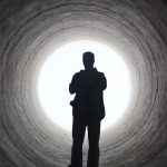 uomo percorre tunnel luminoso
